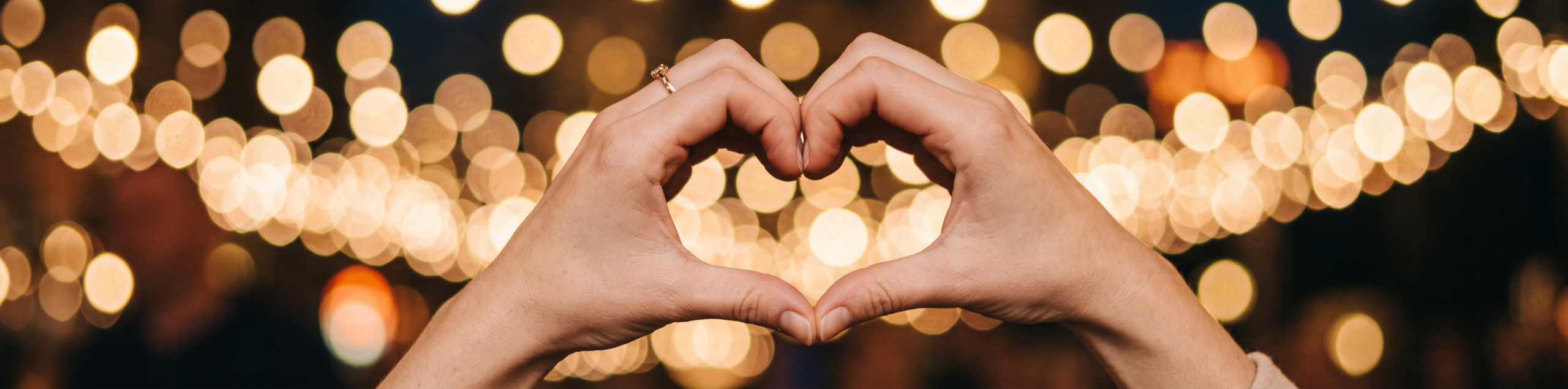 Hands forming a heart shape with a ring
